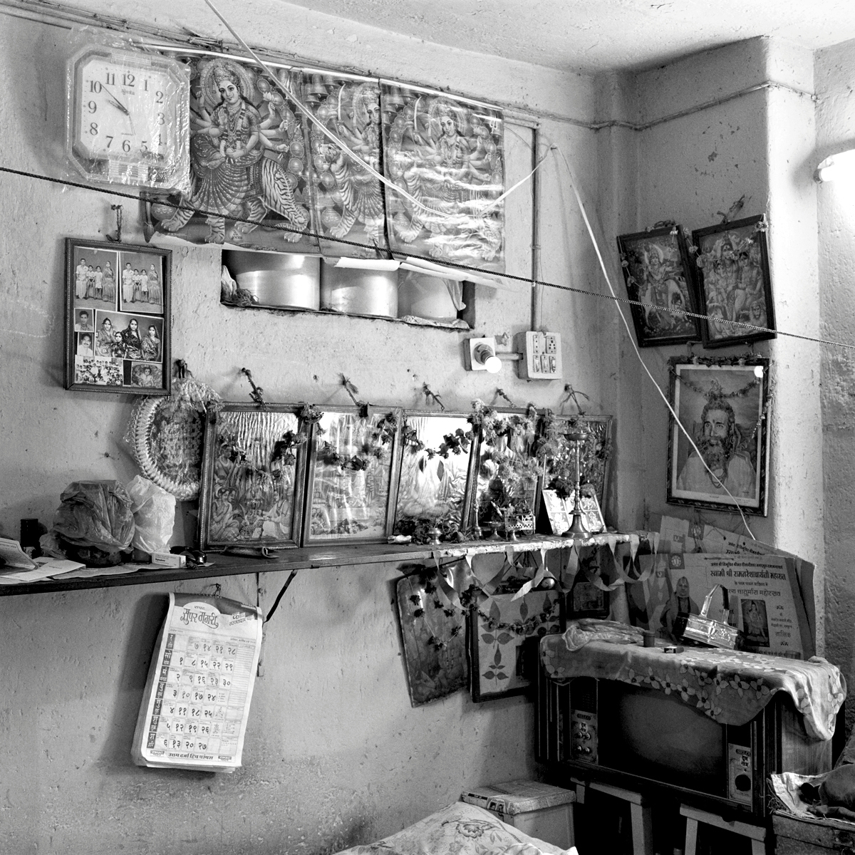 Residential interior with display of gods pictures and a TV set, Nasik, Maharashtra.